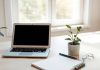 A bright financial workspace with a laptop and notepad.