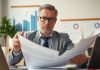 Investor analyzing financial documents in a modern office.