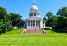 New York State Capitol building with blue sky and greenery.