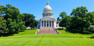 New York State Capitol building with blue sky and greenery.