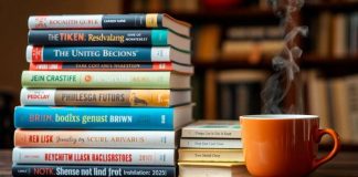 Stack of books with a coffee cup nearby.