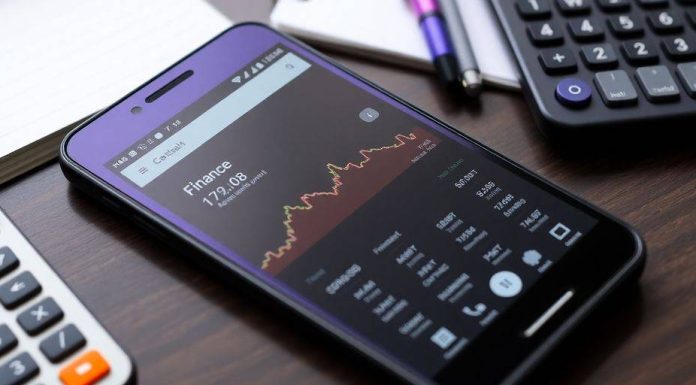 Smartphone with Google Finance app on a stylish desk.