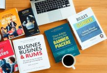 Flat lay of business books and workspace items.