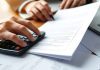 Financial professional reviewing private security documents at desk.