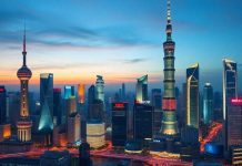 Shanghai skyline at dusk with illuminated buildings.